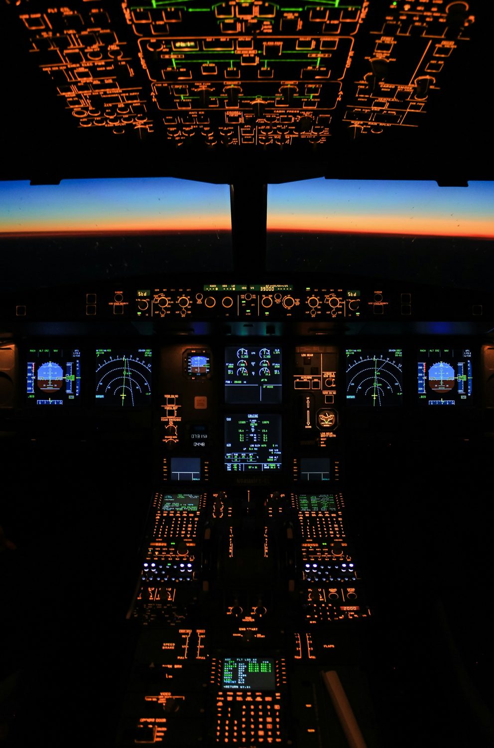 Airliner cockpit at dawn, the sun coming up at the end of a night flight